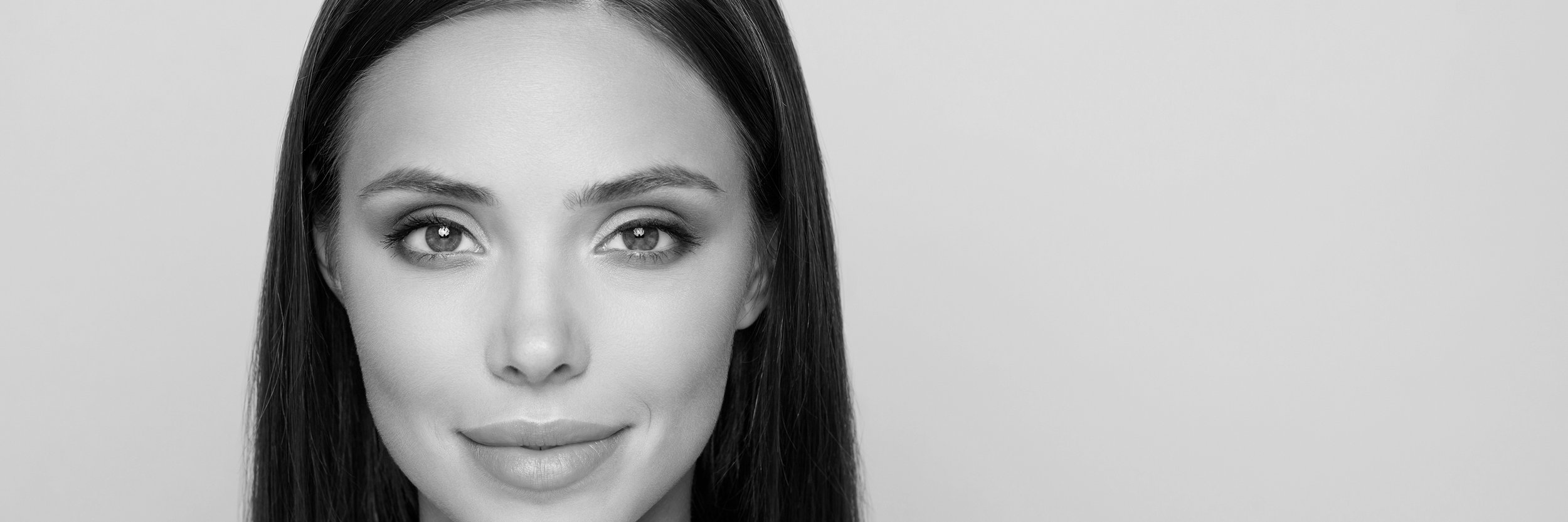 Black and white portrait of a woman with straight hair, neutral expression.